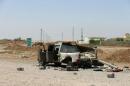 The wreckage of a car belonging to Islamic State militants lies along a road after it was targeted by a U.S. air strike at Mosul Dam