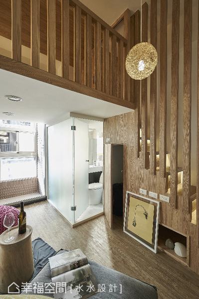 沿著梯下的木紋牆面，挖出一處可供收納的絕佳的規劃；衛浴空間則以霧面玻璃隔間，視覺的穿透美感讓空間更顯放大。