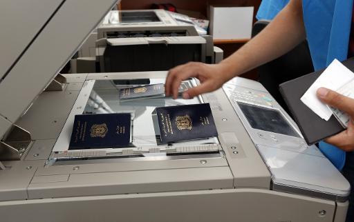 A UNHCR (United Nations Refugee Agency) employee scans passports of Syrian refugees at a UNHCR registration center, one of many across Lebanon, in the northern port city of Tripoli on May 29, 2014