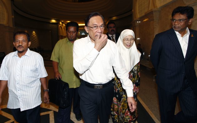 File photo shows Datuk Seri Anwar Ibrahim (centre) and his wife Datuk Seri Dr Wan Azizah arriving at the court house in Putrajaya March 7, 2014. — Reuters pic