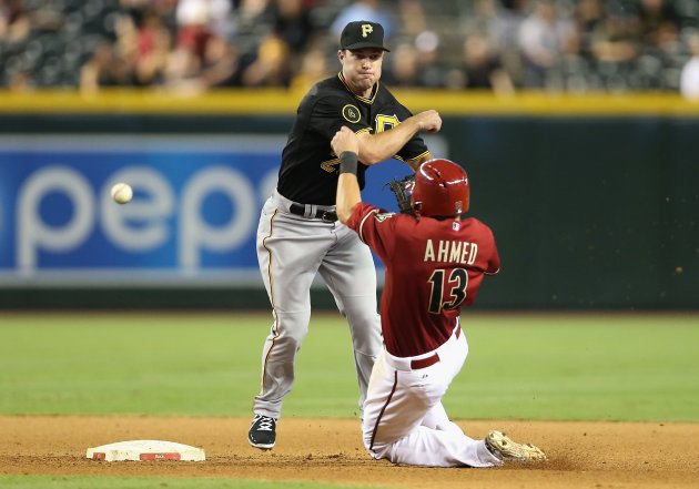 PHOENIX, AZ - AUGUST 03: Infielder Jayson Nix #27 of the Pittsburgh Pirates has his throw blocked by the diving Nick Ahmed #13 of the Arizona Diamondbacks allowing the game winning run to score during the tenth inning of the MLB game at Chase Field on August 3, 2014 in Phoenix, Arizona. The Diamondbacks defeated the Pirates 3-2 in 10 innings. (Photo by Christian Petersen/Getty Images)