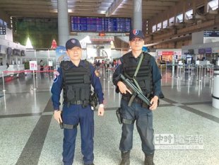 員警荷槍實彈在小港機場出境大廳加強巡邏。（張啟芳攝）