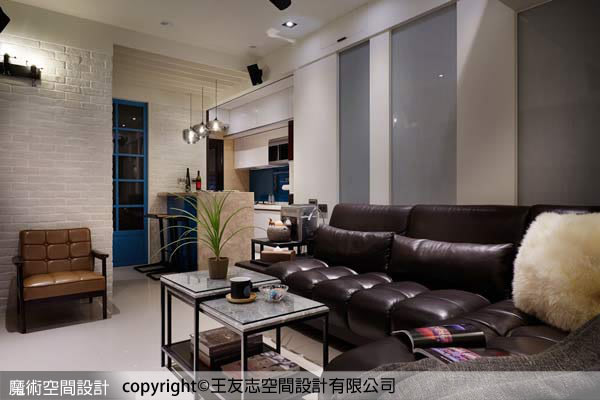 沙發後方牆壁由木板與絹絲玻璃組成，清爽用色輔以上方天花LED嵌燈照射，柔和光影變化塑造迷人寧靜調性。