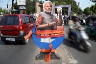 A cutout of Chief Minister of western Gujarat state and main opposition Bharatiya Janata Party (BJP) prime ministerial candidate Narendra Modi is fixed onto a roadsign at a busy intersection in Vadodara on May 16, 2014