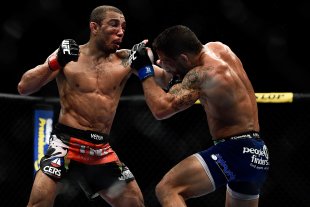 Jose Aldo (L) punches Chad Mendes during UFC 179 in October 2014. (Getty)
