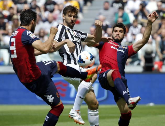 Juventus' Fernando Llorente fights for the ball with Cagliari's Davide Astori and Luca Rossetti during their Italian Serie A soccer match at Juventus stadium in Turin