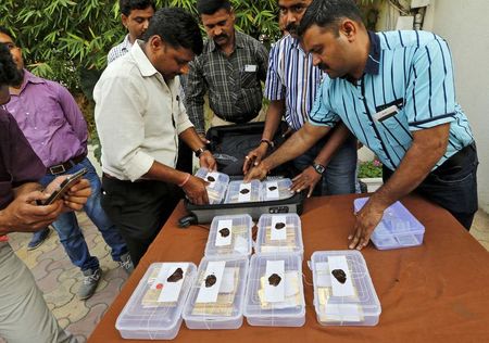 Indian police officials pack seized gold bars in a bag after they displayed it at a police station in the western Indian city of Ahmedabad February 24, 2015. REUTERS/Amit Dave