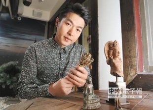 ↑李威手拿明朝永樂時期的法器，桌上是他收藏的３尊藏傳佛像，有千百年歷史。（粘耿豪攝）
