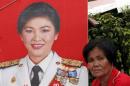 A member of the pro-government "red shirt"   group rests next to a portrait of Thailand's Prime Minister Yingluck   Shinawatra during a rally in Nakhon Pathom province on the outskirts of Bangkok   April 5, 2014. REUTERS/Chaiwat Subprasom