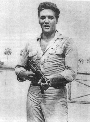 A rare picture of Elvis when he was in the army, with a machine gun.