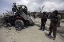 Afghan security forces inspect at the site of   yesterday's car bomb attack on a market in Urgon district, Paktika