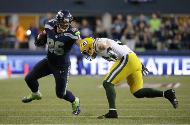 Seattle Seahawks ala cerrada Zach Miller, izquierda, corre la pelota como los Green Bay Packers en el interior apoyador AJ Hawk, a la derecha, se cierra en la segunda mitad de un partido de fútbol de la NFL, Jueves, 04 de septiembre 2014, en S