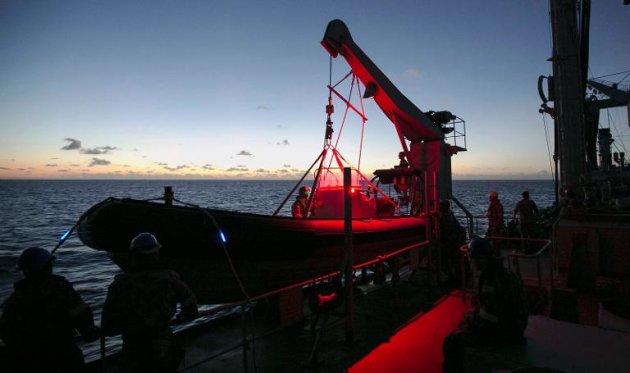 This handout photo taken on April 4, 2014 and released on April 7 by Australia's Defence Department shows the HMAS Success readying a rigid hull inflatable boat (RHIB) near dusk following a reported sighting of potential debris