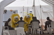 Health workers, attend to patients that contracted the Ebola virus, at a clinic in Monrovia, Liberia, Monday, Sept. 8, 2014. Border closures, flight bans and mass quarantines are creating a sense of siege in the West African countries affected by Ebola, officials at an emergency African Union meeting said Monday, as Senegal agreed to allow humanitarian aid pass through its closed borders. (AP Photo/Abbas Dulleh)