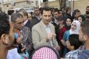 Syrian President Bashar al-Assad (C) chats with people during his visit to Ein al-Tinah village