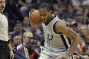 Kawhi Leonard controla el balón por los Spurs de San Antonio, tras la caída de Darius Miller, de los Pelicans de Nueva Orleáns, en el duelo del sábado 29 de marzo de 2014 (AP Foto/Darren Abate)