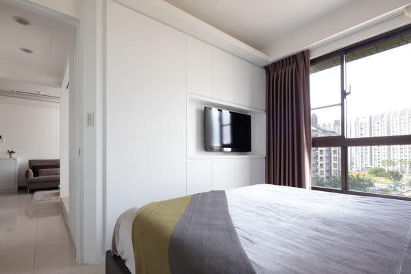 主卧室電視牆以雙面櫃的設計，讓兩個空間能共享實用的機能。