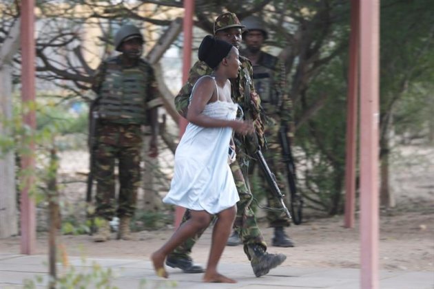 Un militar ayuda a una mujer que ha escapado de la Universidad de Garissa, en el este de Kenia, donde al menos 15 personas han muerto y otras 65 han resultado heridas en un ataque con rehenes reivindicado por el grupo islamista Al Shabab, hoy, jueves 2 de abril de 2015. En estos momentos, se está llevando a cabo una acción conjunta de las Fuerzas de Defensa y la Policía que ya ha conseguido evacuar tres de las cuatro residencias universitarias, mientras que los atacantes siguen atrincherados en una de ellas con un número desconocido de rehenes. EFE/Dai Kurokawa
