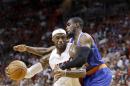 LeBron James del Heat de Miami es objeto de una falta cometida por Tim Hardaway Jr., (derecha) de los Knicks de Nueva York el domingo 6 de abril de 2014. (AP Foto/Wilfredo Lee)