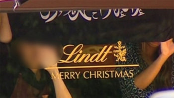 Hostages hold a black flag with white Arabic writing in the Lindt cafe in Sydney, Australia.