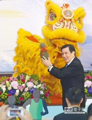 馬英九總統南下高雄主持國家運動訓練中心揭牌儀式，由祥獅口中接下象徵吉利的鳳梨。（謝明祚攝）