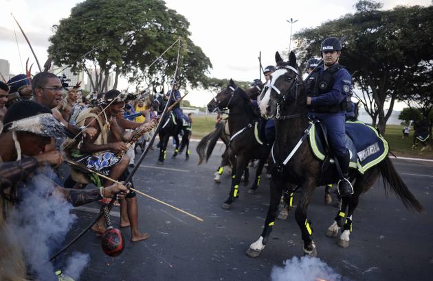 Police use tear gas to impede native Brazilians from marching towards the Mane Garrincha soccer stadium during a demonstration in Brasilia