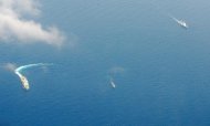 China Coast Guard ships (L and R) and a Philippine supply boat (C) engage in a stand off as the Philippine boat attempts to reach the Second Thomas Shoal, a remote South China Sea a reef claimed by both countries, on March 29, 2014