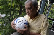 Indian football enthusiast Pannalal Chatterjee poses on his balcony with a football before going to his regular football practice at a local ground in Kolkata on June 12, 2010