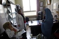 A afegã Bassira, 38 anos, diagnosticada com câncer de mama, conversa com médicas em hospital de Herat, em 2 de abril de 2014