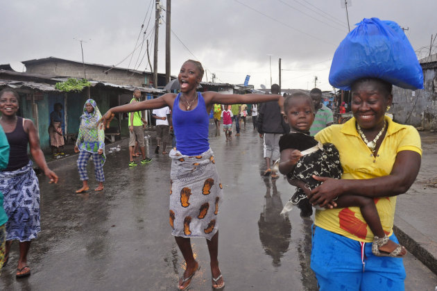 A woman, center, reacts as she and others celebrate on the streets outside of West Point, that have been closed in by Liberian security forces to stop all movement the past week in a attempt to control the Ebola outbreak in Monrovia, Liberia, Saturday, Aug. 30, 2014. Liberia says it will open up a slum in its capital where thousands of people were barricaded to contain the spread of Ebola. Information Minister Lewis Brown says lifting the quarantine Saturday morning will not mean there is no Ebola in the West Point Slum. (AP Photo/Abbas Dulleh)