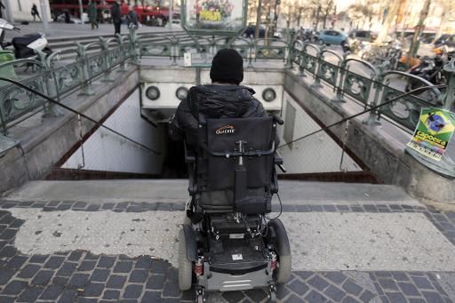 Un homme en fauteuil-roulant bloqué devant les escaliers du métro