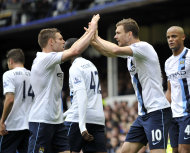 Manchester City's Edin Dzeko, right, celebrates with teammate James Milner after scoring the second goal of the game during their English Premier League soccer match against Everton at Goodison Park in Liverpool, England, Saturday May 3, 2014. (AP Photo/Clint Hughes)