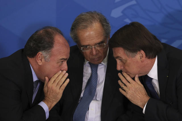 Senate leader Fernando Bezerra, from left, Economy Minister Paulo Guedes, Brazil's President Jair Bolsonaro, attend a signing ceremony for a decree on Regional Development, at the Planalto Presidential Palace, in Brasilia, Brazil, Thursday, May 30, 2019. (AP Photo/Eraldo Peres)