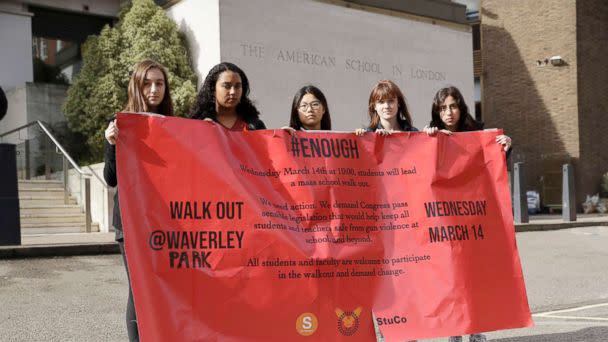 PHOTO: Students pose for photographs with a banner outside the front of the American School in London, after taking part in a 17-minute walkout in the school playground, which was attended by approximately 300 students aged 14-18, March 14, 2018. (Matt Dunham/AP)
