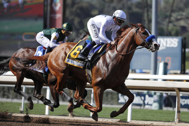 Justify, ridden by Mike Smith, gallops past Bolt d'Oro, left, with jockey Javier Castellano, during the Santa Anita Derby horse race at Santa Anita on Saturday, April 7, 2018, in Arcadia, Calif. Justify won the race, and Bolt d'Oro came in second. (AP Photo/Jae C. Hong)