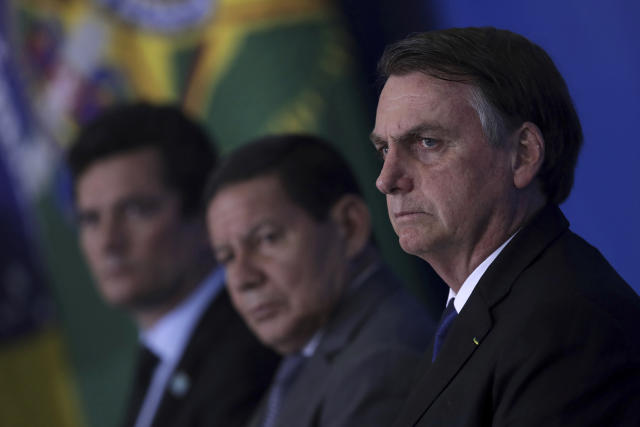 Brazil's President Jair Bolsonaro attends a ceremony where he signed a second decree that eases gun restrictions, during the signing ceremony at Planalto presidential palace in Brasilia, Brazil, Tuesday, May 7, 2019. The decree opens Brazil’s market to guns and ammunition made outside of Brazil according to a summary of the decree. Gun owners can now buy between 1,000 -5,000 rounds of ammunition per year depending on their license, up from 50 rounds. Lower-ranking military members can now carry guns after 10 years of service. (AP Photo/Eraldo Peres)