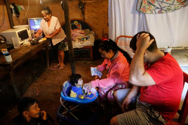 The Gutierrez family, diplaced by floods, prepare for breakfast in a temporary shelter in Asuncion, Paraguay, Friday, April 5, 2019.