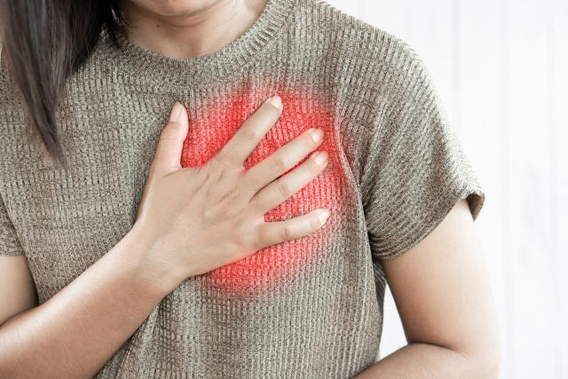 woman hand touching her chest having heart attack