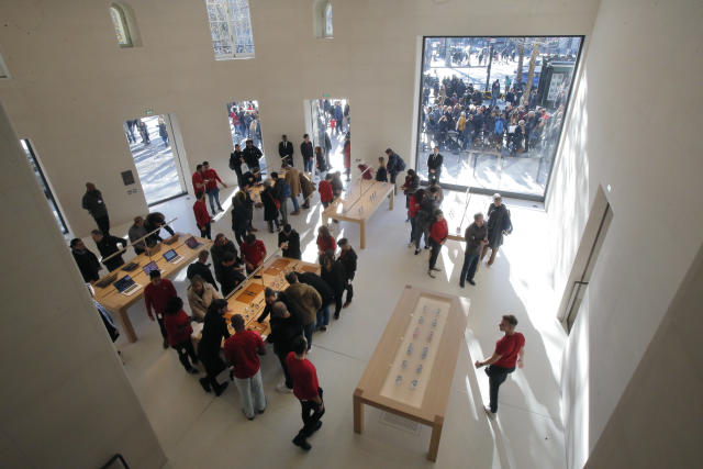 Customers stroll in side the new Apple store at the Champs Elysees avenue in Paris, France, Sunday, Nov. 18, 2018. Apple open today its latest retail location at the Camps Elysees avenue. (AP Photo/Michel Euler)