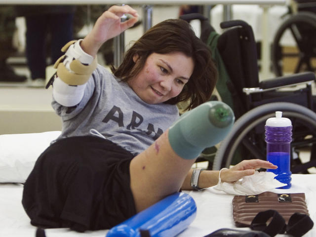 FILE - In this Jan. 31, 2005, file photo, Army Major Tammy Duckworth rolls herself up during physical therapy at the Walter Reed Army Medical Center in Washington. Duckworth lost both legs when the helicopter she was in was struck by a rocket-propelled grenade during a mission near Baghdad on Nov. 12, 2004. (AP Photo/The Arizona Republic, Michael Chow)