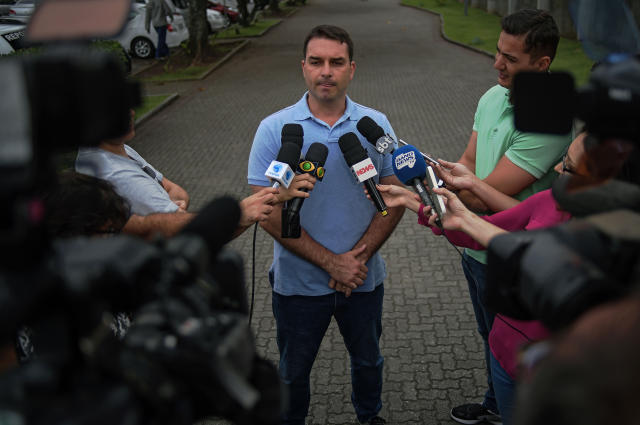 Flavio Bolsonaro (C), the son of Brazil's right-wing presidential candidate for the Social Liberal Party (PSL) Jair Bolsonaro, talks to the media outside his father's residence in Rio de Janeiro, Brazil, on October 8, 2018. - A deeply polarized Brazil stood at a political crossroads on october 8, 2018 as the bruising first round of the presidential election left voters with a stark choice in the run-off between far-right firebrand Jair Bolsonaro and leftist Fernando Haddad. Bolsonaro won 46 percent of the vote to Haddad's 29 percent, according to official results. (Photo by CARL DE SOUZA / AFP) (Photo credit should read CARL DE SOUZA/AFP/Getty Images)