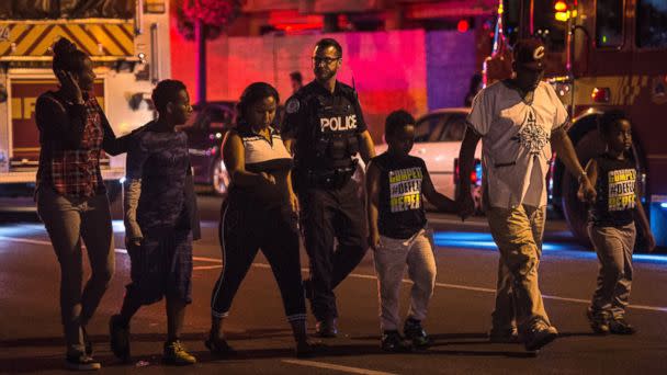 Police escort civilians away from the scene of a shooting, Sunday, July 22, 2018, in Toronto. [AP)