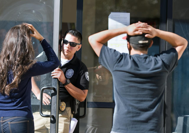 SANTA ANA, CA - APRIL 27: A security guard inside Everest College keeps away a member of the media and a former student Gary Montano after the embattled for-profit Santa Ana school was shut down along with 28 others on Monday. Montano, 30 who graduated two years ago, was trying to collect his transcripts and diploma. 