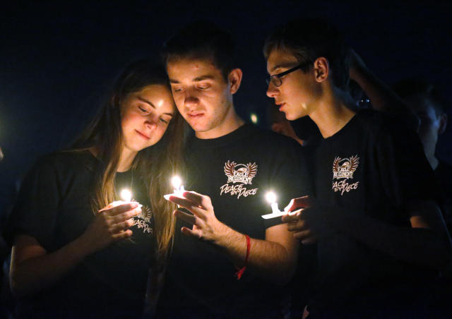 Attendees comfort each other at a candlelight vigil for the victims of the shooting at Marjory Stoneman Douglas High School, Feb. 15, 2018, in Parkland, Fla.